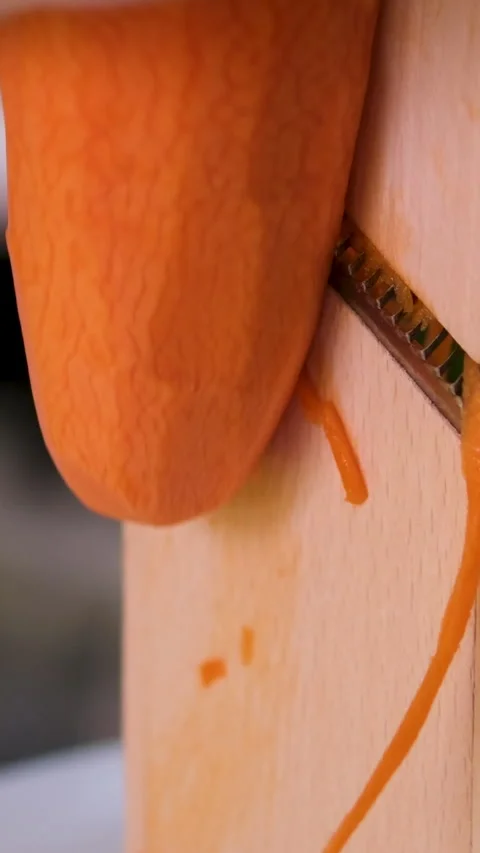 Grate carrots to make salads close up, details. View inside an iron grater with Stock Footage 302730633