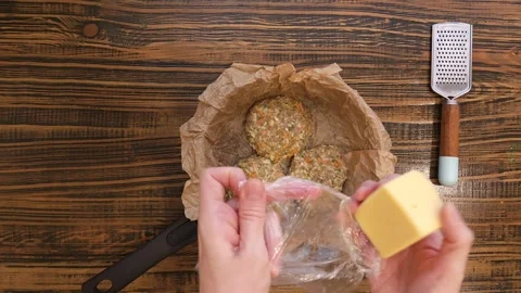 Grate cheese on meat patties in a baking pan Stock Footage 315248839