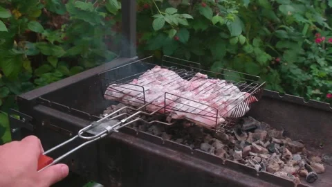 Grate with chicken turns over brazier with the burning coals Stock Footage 157610491