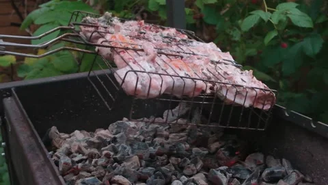 Grate with chicken turns over brazier with the burning coals Stock Footage 157630236