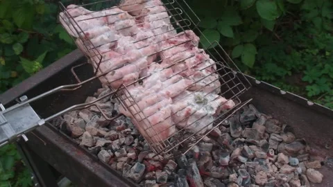 Grate with chicken turns over brazier with the burning coals Video stock 157630448