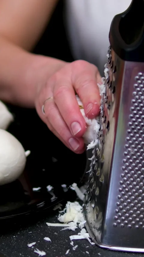 Grate Mozzarella cheese Grating fresh cheese in the kitchen for delicious meals Vídeos de archivo 306723310