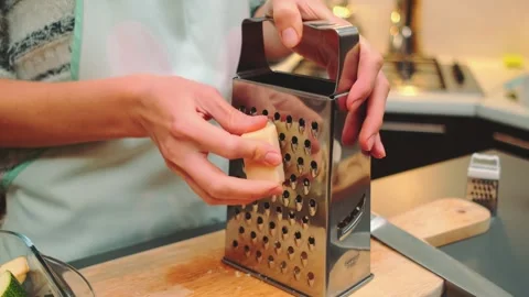 Grate parmesan on a coarse grater in the kitchen Video stock 252269792