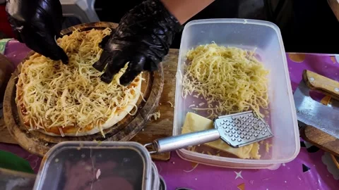 Grated Cheese Being Added to Pizza During Preparation 動画素材 342500352