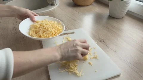 Grated Cheese Being Collected Into Plate From Cutting Board Cooking Preparation Video stock 336447368