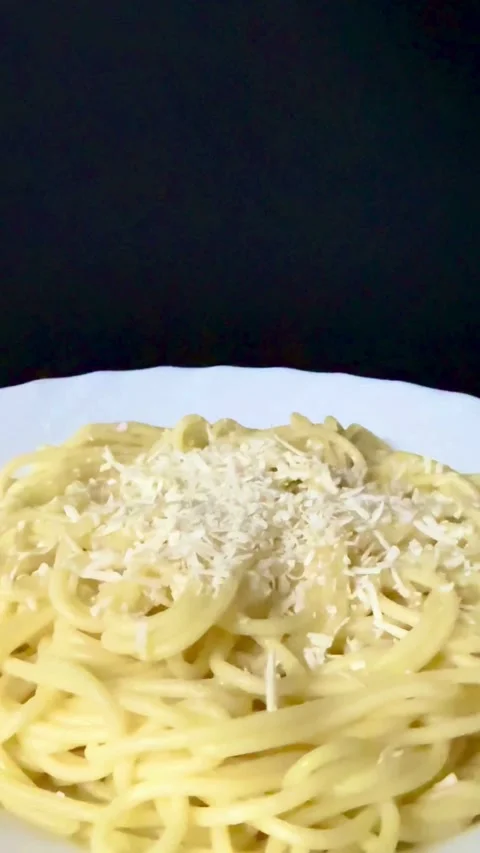 Grated cheese being sprinkled on hot spaghetti pasta dish Stock Footage 331982936