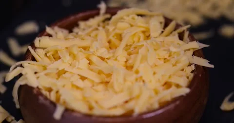 Grated cheese for cooking close up, grated cheese for cooking and folded into a Stock Footage 313847461