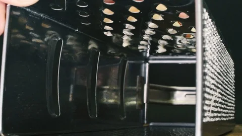 Grated cheese falls inside a grater in slowmotion Video stock 111567229