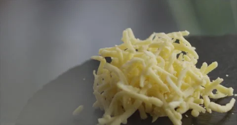 Grated cheese falls on mirror surface in slow motion Stock Footage 198344374