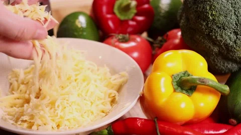 Grated cheese on a table full of vegetables. Vídeos de archivo 144023557