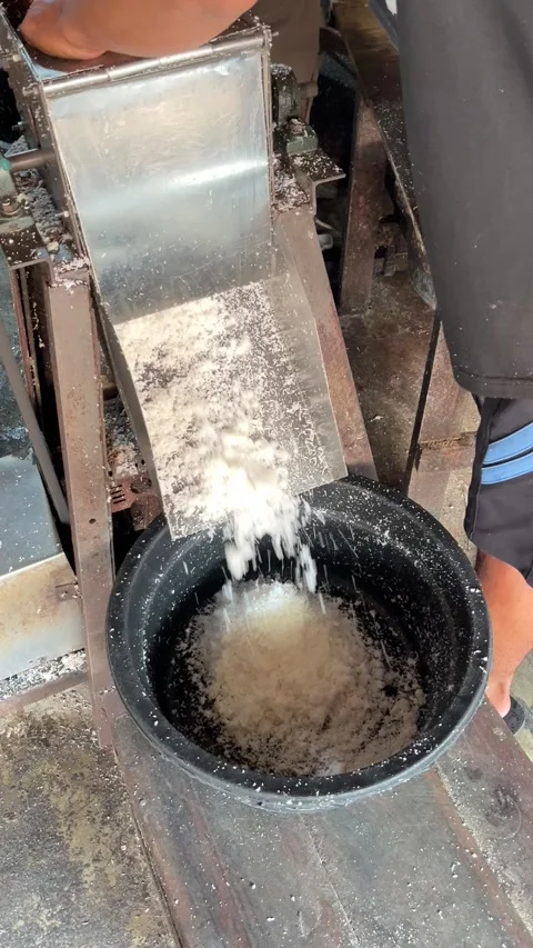 Grated coconut falling from an electric grating machine 動画素材 335805047