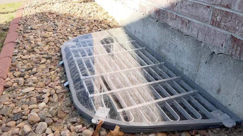 Grated cover protecting basement window well Stock Footage 324510520