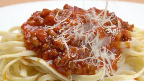 Grated hard Parmesan cheese is sprinkled on top of the Balagnaise Stock Footage 296581746