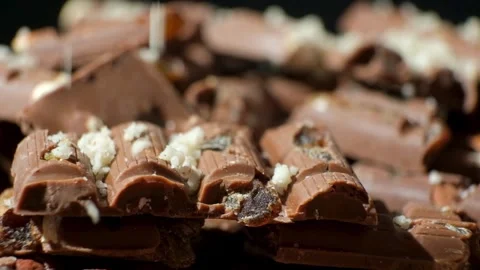 Grated nuts are sprinkled on nutty milk chocolate Stock Footage 291966436
