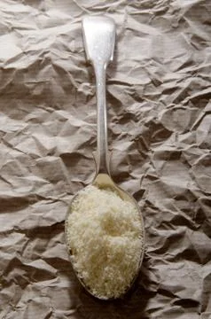Grated parmesan cheese on a spoon Stock Photos