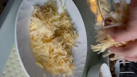 Grated potatoes fall into the plate Stock Footage 167506796