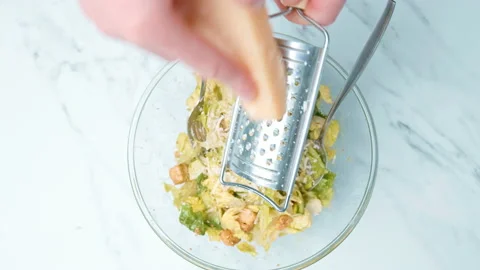 Grating and sprinkling parmesan cheese on freshly made Caesar Salad in 4K. Stock Footage 140768808
