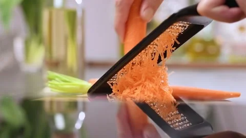 Grating carrot with a grater in the kitchen. Stock Footage 151195871