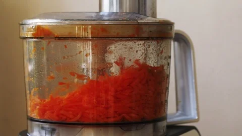 Grating carrots using a food processor Stock Footage 78489567