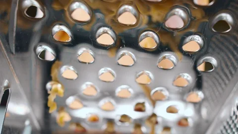 Grating cheese with metal grater in the kitchen. Close-up shot inside the grater Stock Footage 111633945