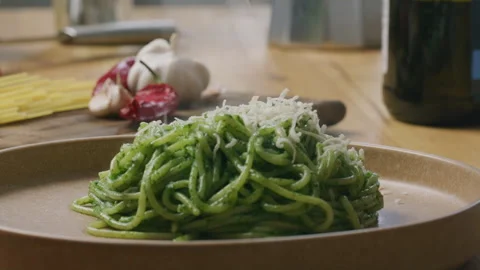 Grating Cheese over Hot Pasta with Spinach Sauce on Plate Stock Footage 288755016