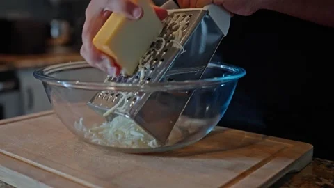 Grating Cheese for the Perfect Melt Stockbeeldmateriaal 325222888