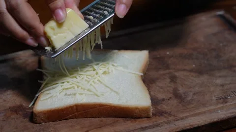 Grating cheese on a sheet of white bread Stock Footage 287681208