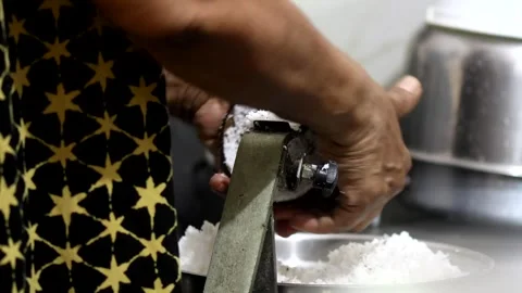 Grating coconut by hand using non-mechanical coconut grater. Stock Footage 252578431