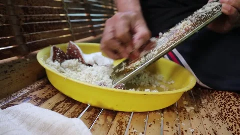 Grating coconut by hand without an electric grater. Video stock 341835099