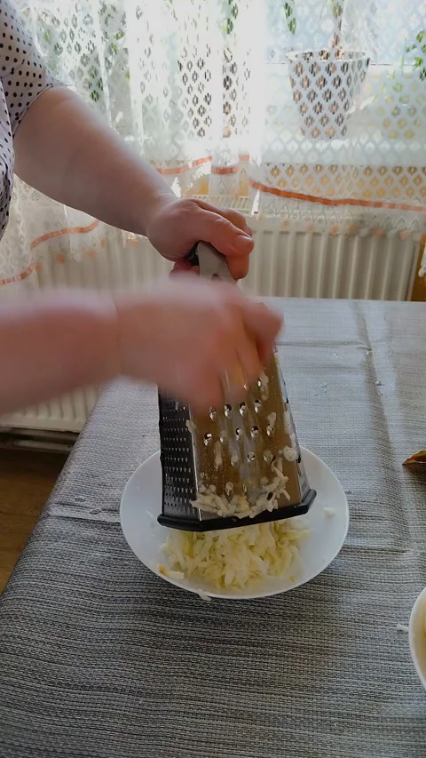 Grating fresh apples on a metal pie grater Stock Footage 334664227