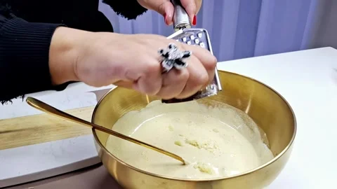 Grating Fresh Garlic Cloves into Gourmet Sauce in Golden Bowl Stock Footage 333373152