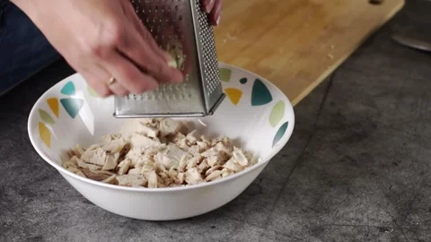 Grating Fresh Garlic Over the Shredded Chicken in a Bowl Ready to be Served and Stock Footage 303373899