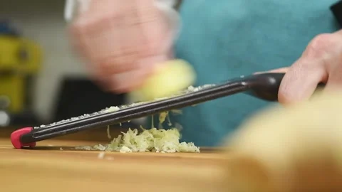 Grating ginger root with a grater in the kitchen. Stock Footage 171186377