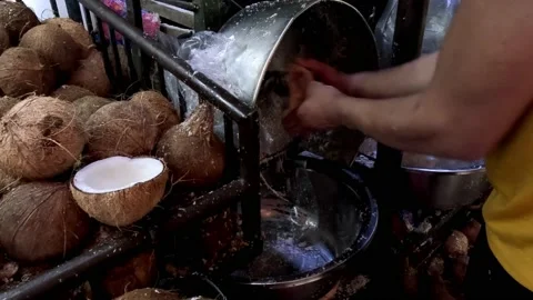 Grating Old Coconut With a Grinder Machine in a Market Stock Footage 233976343