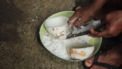 A grating an old coconut with a traditional coconut grater Video stock 274385334