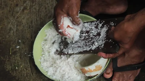 A grating an old coconut with a traditional coconut grater Video stock 274385376