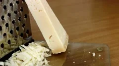 Parmesan Cheese And Grater Close Up. An Angled View Of A Block Wedge Of  Parmesan Cheese With Shredded Pieces All Around And A Metal Cheese Grater  On A Cutting Board Stock Photo