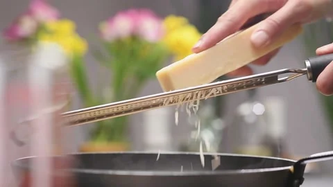 Grating parmesan cheese with a grater in the kitchen. Stock Footage 154939293