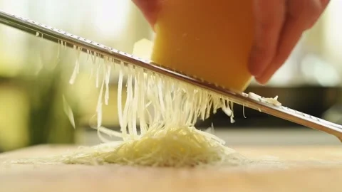 Grating parmesan cheese with a grater in the kitchen. Stock Footage 162057834