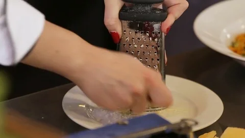 Grating Parmesan to vegetable pasta Stock Footage 74716146