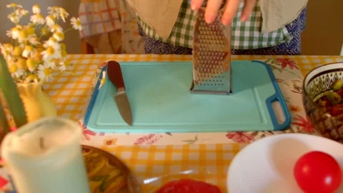 Grating Various Vegetables Using Kitchen Tools on a Blue Cutting Board Stock-Footage 318925742