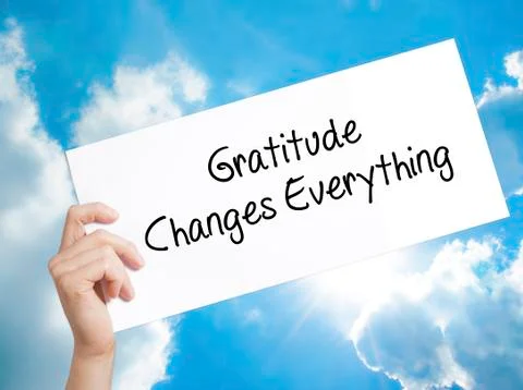 Gratitude Changes Everything Sign on white paper. Man Hand Holding Paper with Stock Photos
