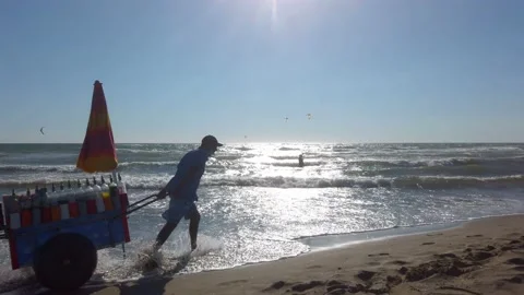 Grattacheccaro. Man carrying drinks and slush on the beach. Fregene, Italy. Stock Footage 135614482