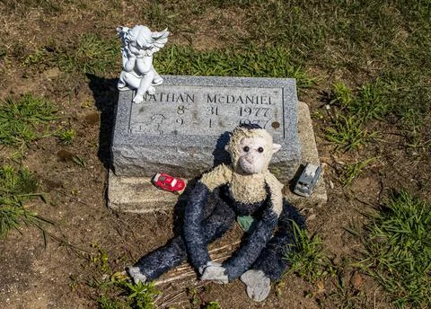 Gravestone with toy monkey Stock Photos