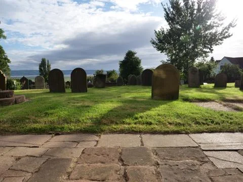 Graveyard with clouds and long shadows Stock Photos
