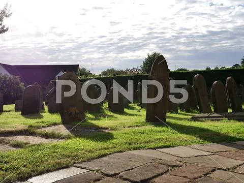 Graveyard with clouds and long shadows Stock Photos