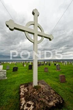 Graveyard cross under storm clouds Stock Photos