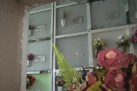 Graveyard man sticks hand into niche Stock Footage