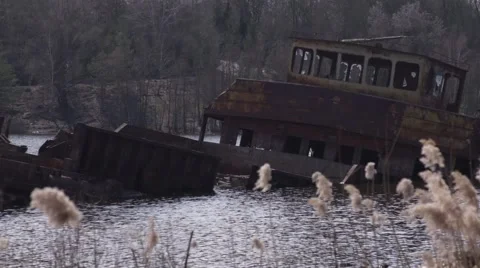 Graveyard of ships on the river.  Many rusty barges and boats in water Stock Footage 62021495