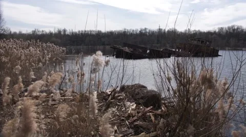 Graveyard of ships on the river.  Many rusty barges and boats in water Stock Footage 62021505